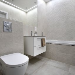 VM-BUD - Nowoczesna łazienka z geometrycznymi płytkami, podwieszana toaleta i szafka z umywalką, lustro z oświetleniem LED, minimalistyczny design.