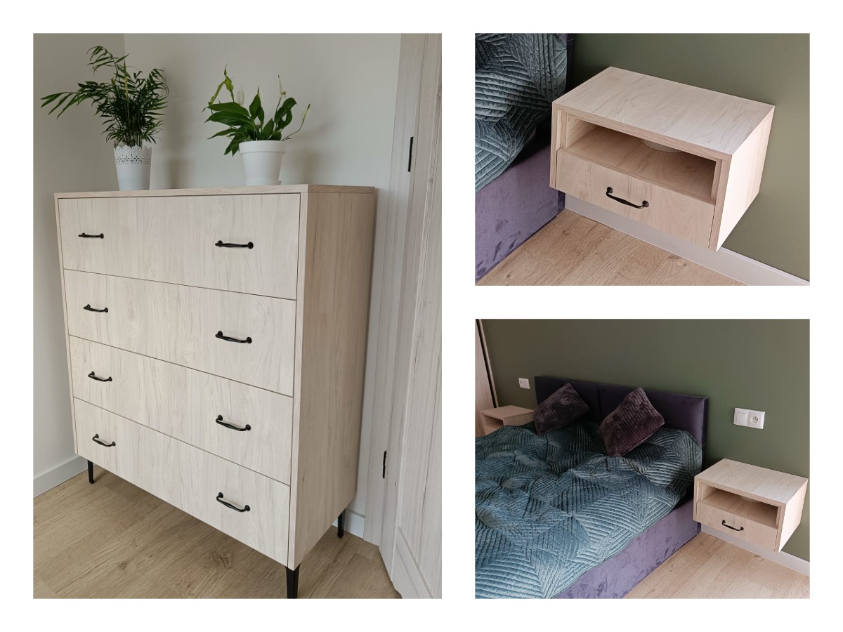 Komoda z czterema szufladami w jasnym odcieniu drewna z czarnymi uchwytami i roślinami doniczkowymi na górze, obok szafka nocna wisząca przy łóżku z szarą tapicerką i zieloną narzutą.