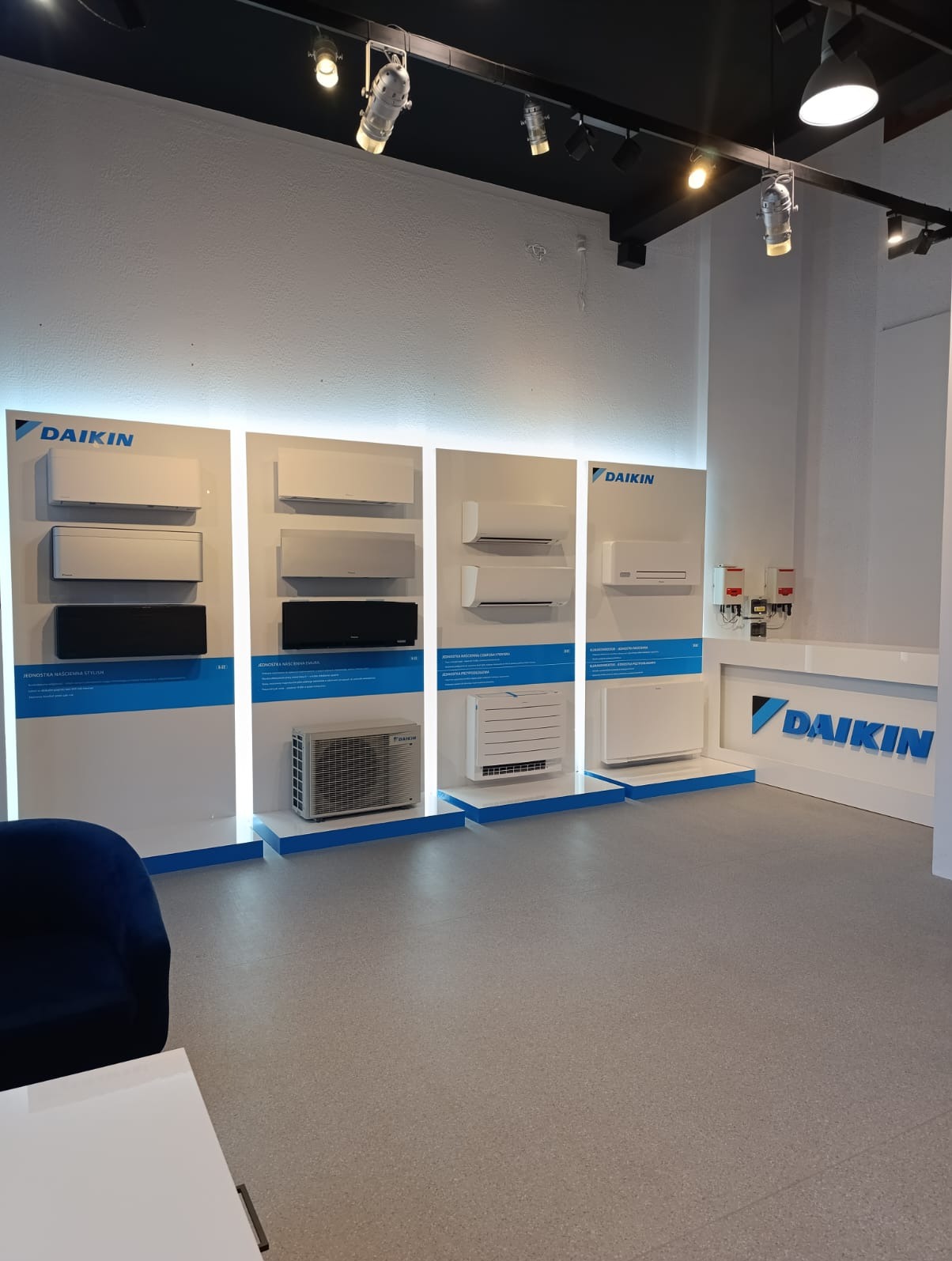 Ekspozycja różnych modeli klimatyzatorów Daikin w salonie firmowym w Białymstoku, z oświetleniem punktowym i minimalistycznym wystrojem.