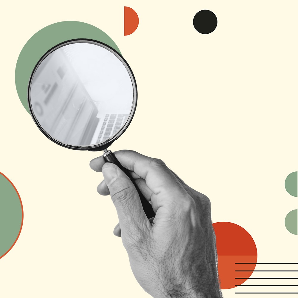 Dłoń trzymająca lupę nad klawiaturą komputera, graficzne elementy w kolorach zieleni i czerwieni na beżowym tle.