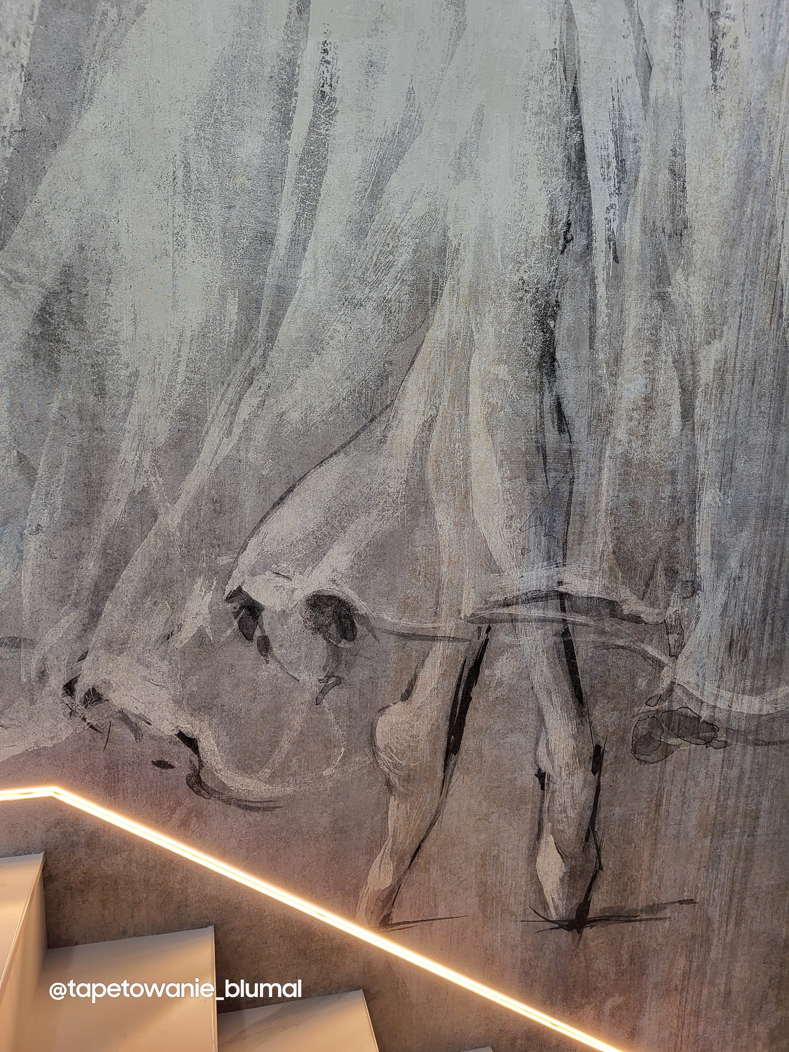 Mural na klatce schodowej z motywem abstrakcyjnym w odcieniach szarości, podświetlony ledami wzdłuż biegu schodów.