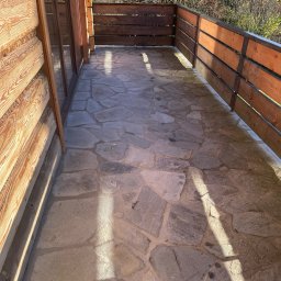 EDIL ART - Balkon z drewnianą balustradą i kamienną posadzką, widok na zalesione wzgórze w słoneczny dzień.