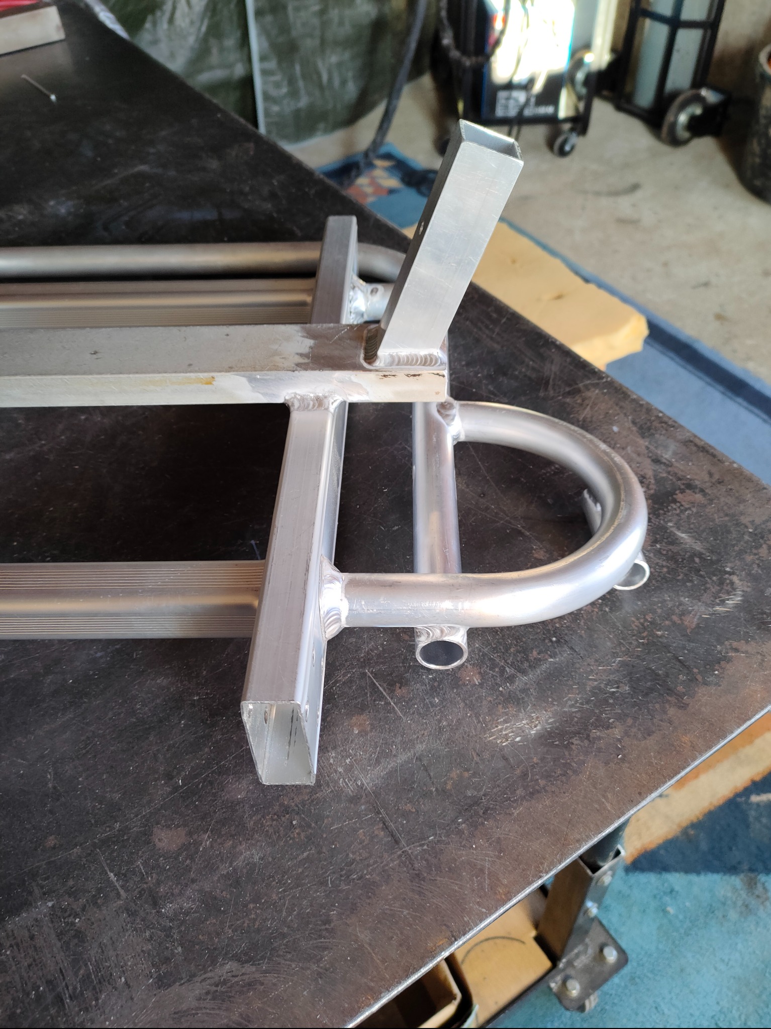 Aluminiowa konstrukcja spawana z profili zamkniętych i rur, widoczne spawy, na stole warsztatowym.