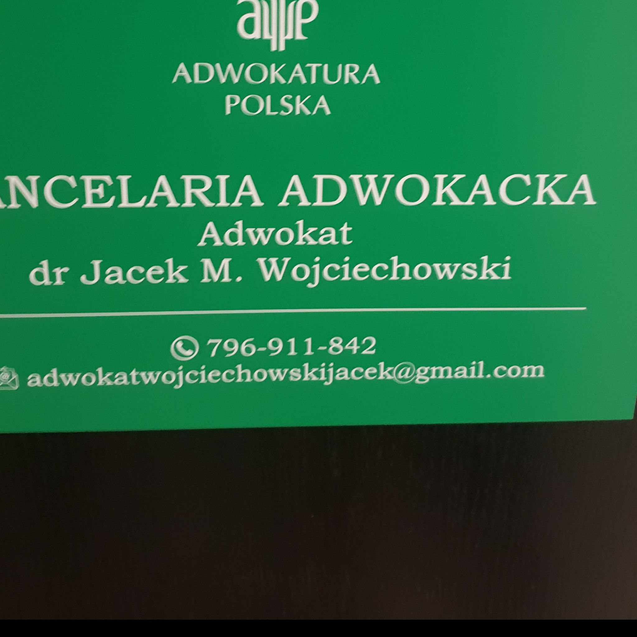 Zielona wizytówka Kancelarii Adwokackiej dr Jacek M. Wojciechowski z numerem telefonu i adresem e-mail.