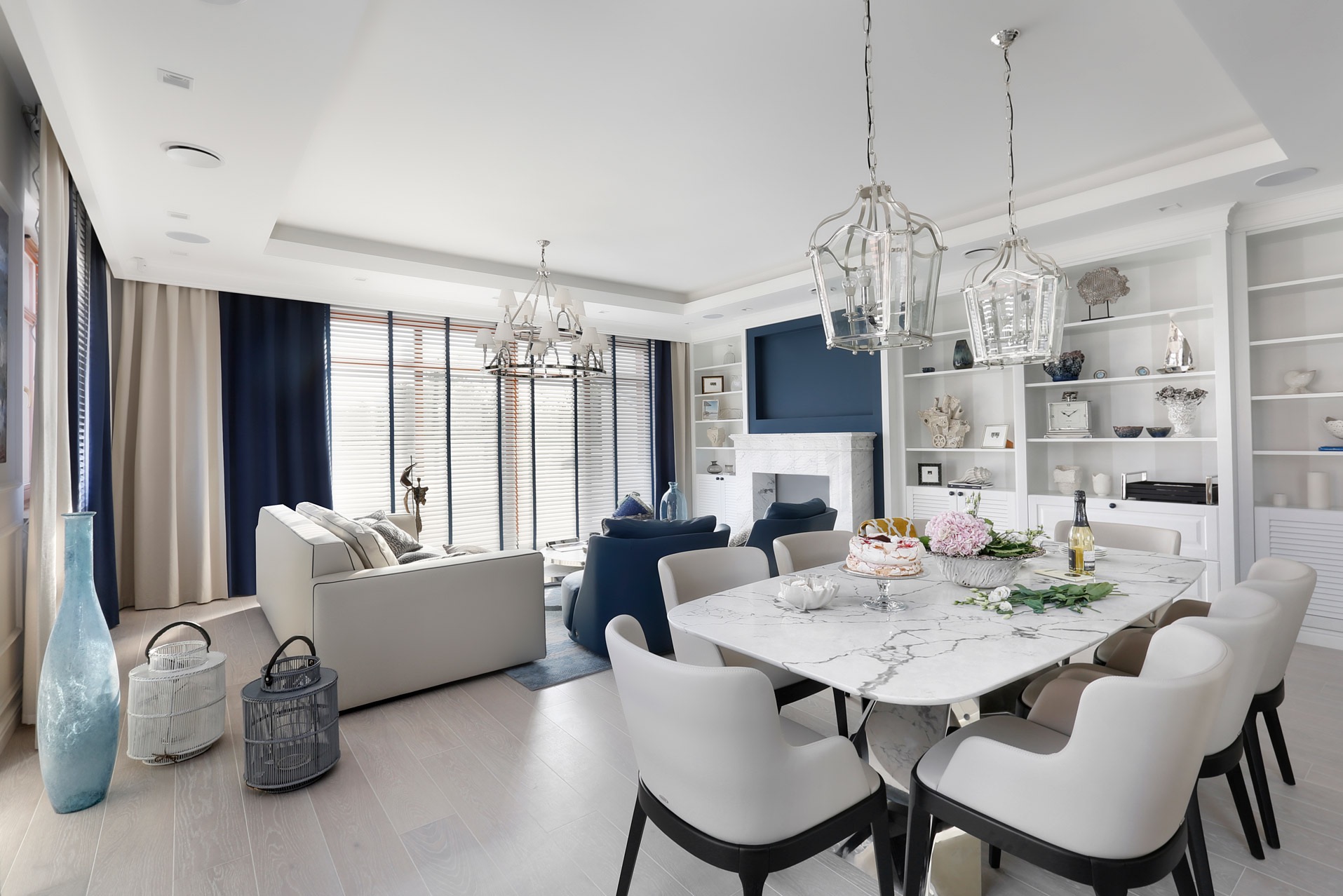 Eleganckie wnętrze salonu z marmurowym stołem, krzesłami, kanapą i dekoracyjnym regałem na ścianie, oświetlone wiszącymi lampami.