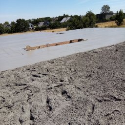 BM TWÓJ DOM SPÓŁKA Z OGRANICZONĄ ODPOWIEDZIALNOŚCIĄ - Wylany fundament pod budowę domu w Rybniku, widoczne ślady butów na świeżym betonie i drewniane szalunki.