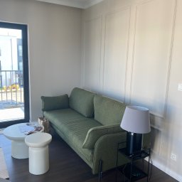 SERHII - BUD SERHII PINKO - Eleganckie wykończenie ścian w salonie z zieloną sofą i stolikiem. Dekoracyjne panele ścienne tworzą subtelny wzór. Nowoczesne wnętrze z dbałością o detale.