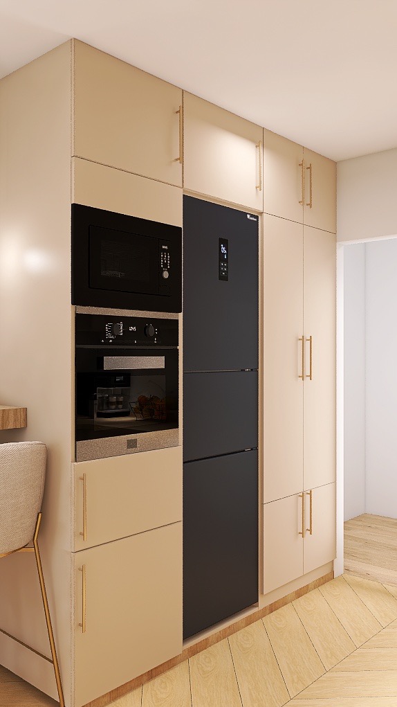 Beżowa zabudowa kuchenna z czarnym sprzętem AGD: piekarnik, mikrofalówka i lodówka. Minimalistyczny styl, złote uchwyty. Fragment krzesła barowego. Jasna podłoga.
