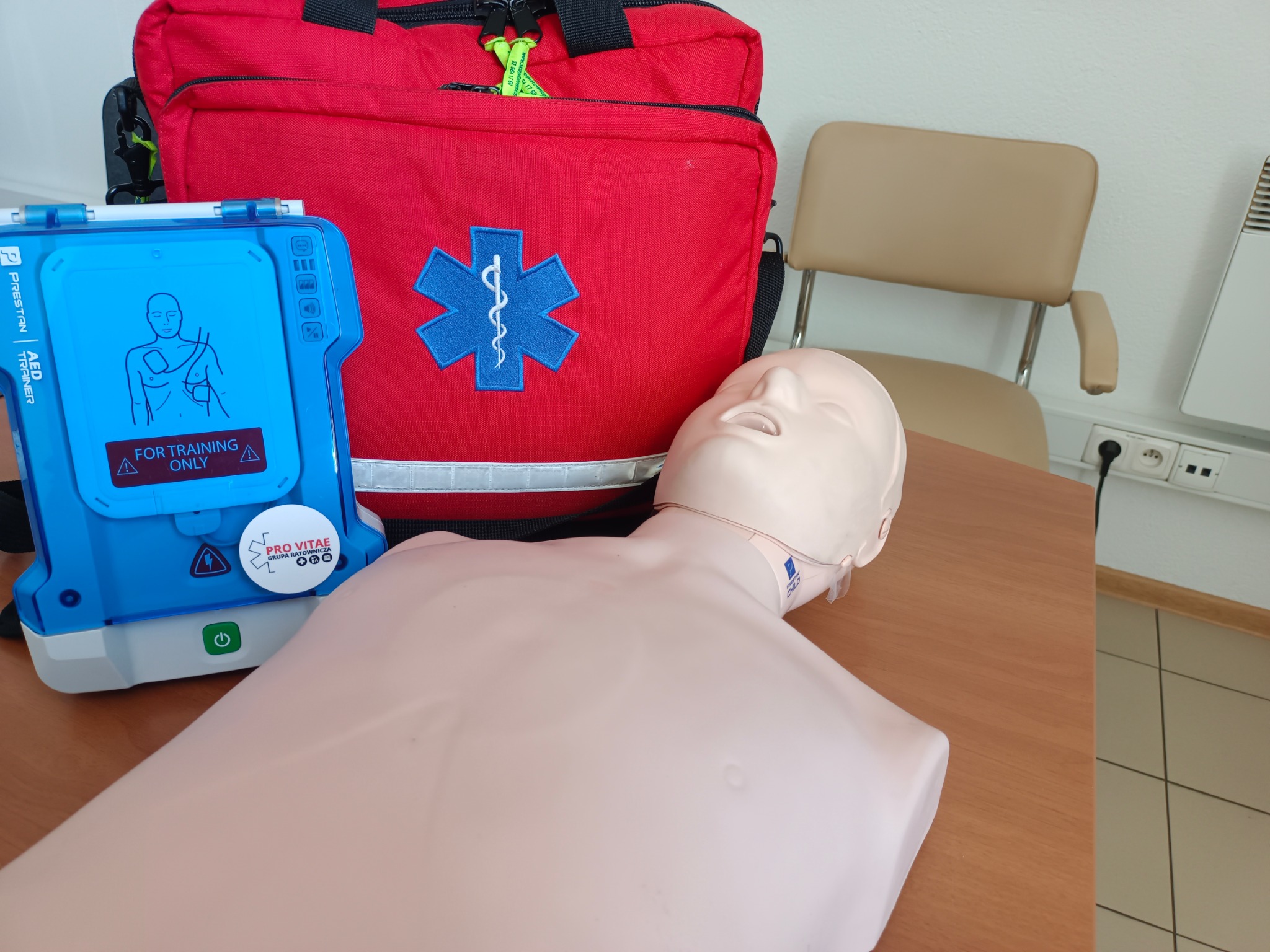 Manekin do resuscytacji, defibrylator treningowy i torba medyczna. Sprzęt do ćwiczeń z zakresu pierwszej pomocy.