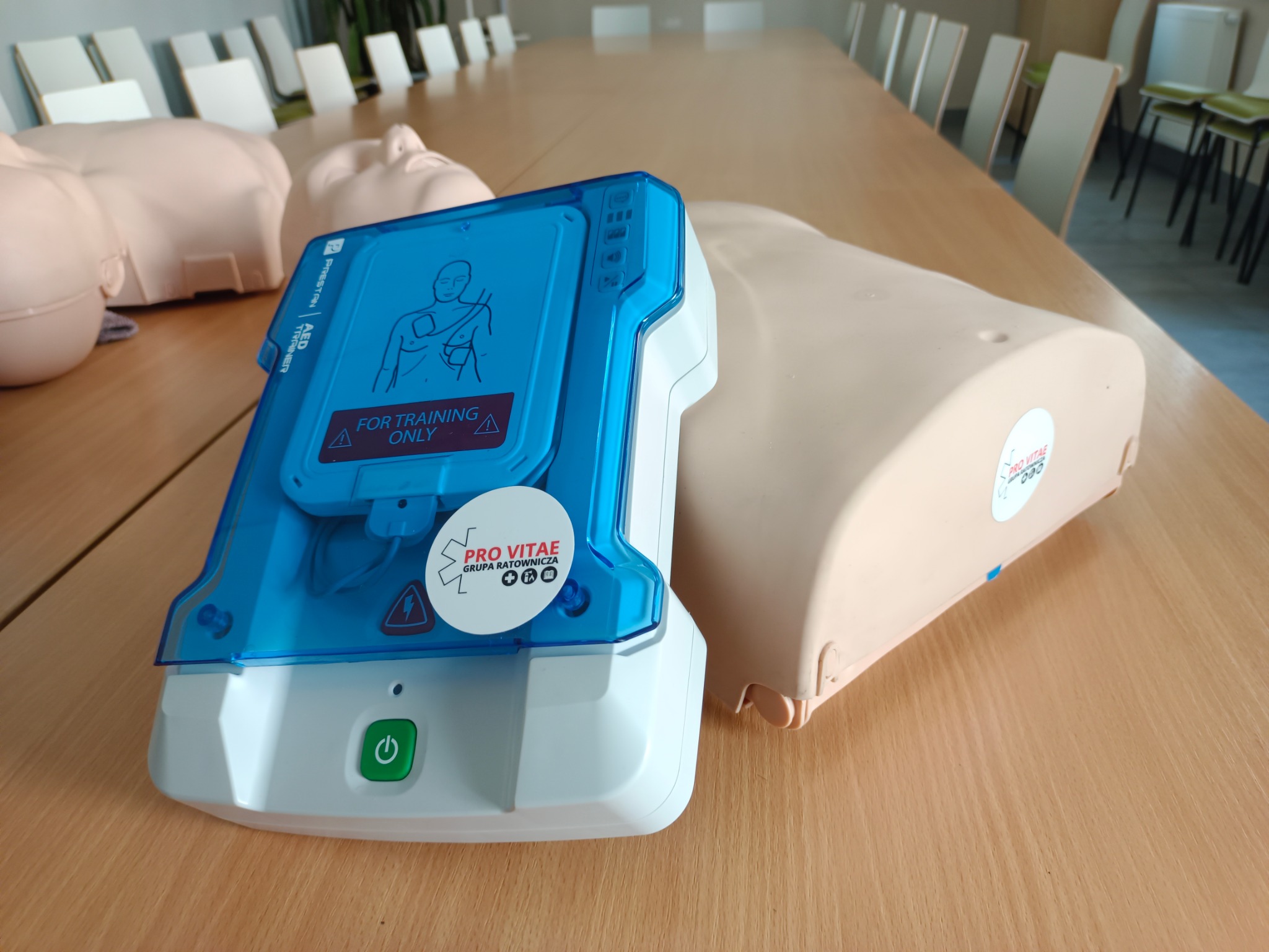 Fantomy i defibrylator treningowy Pro Vitae w Łaziskach Górnych. Sprzęt do nauki pierwszej pomocy, manekin z naklejką 'Pro Vitae Grupa Ratownicza'.