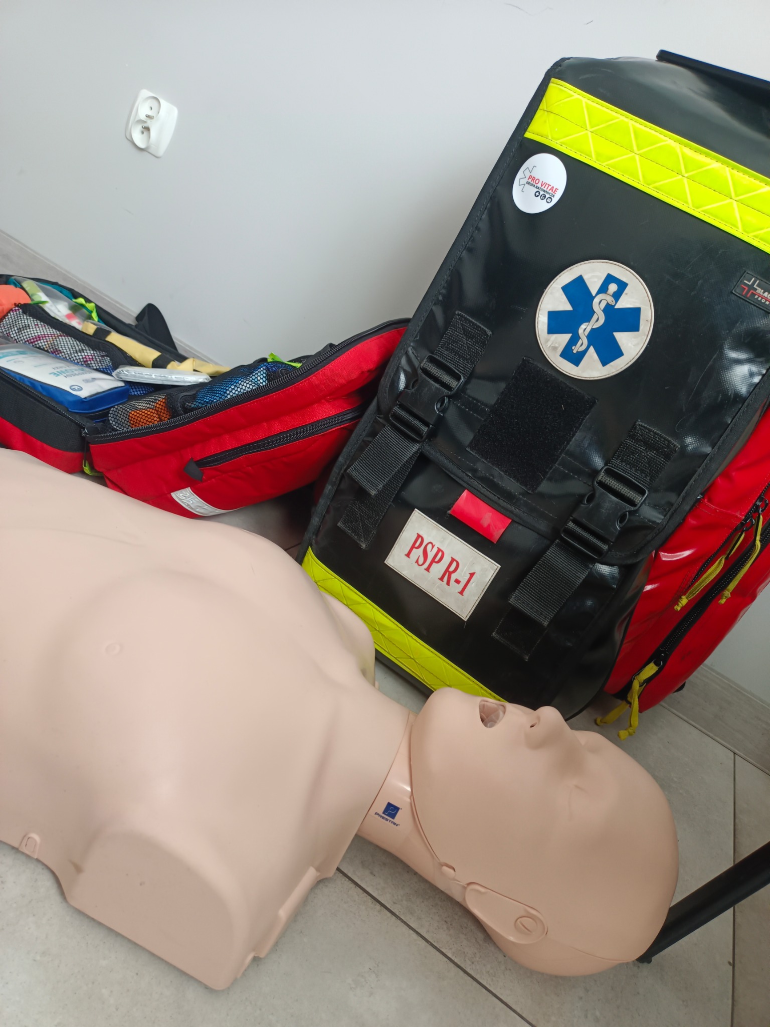 Fantoma do resuscytacji i torba ratownicza PSP R-1 z wyposażeniem, używane podczas zajęć praktycznych na kursie pierwszej pomocy.