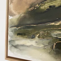Abstrakcyjny obraz z fakturą, w odcieniach brązu, zieleni i bieli, z akcentami złota, oprawiony w drewnianą ramę.