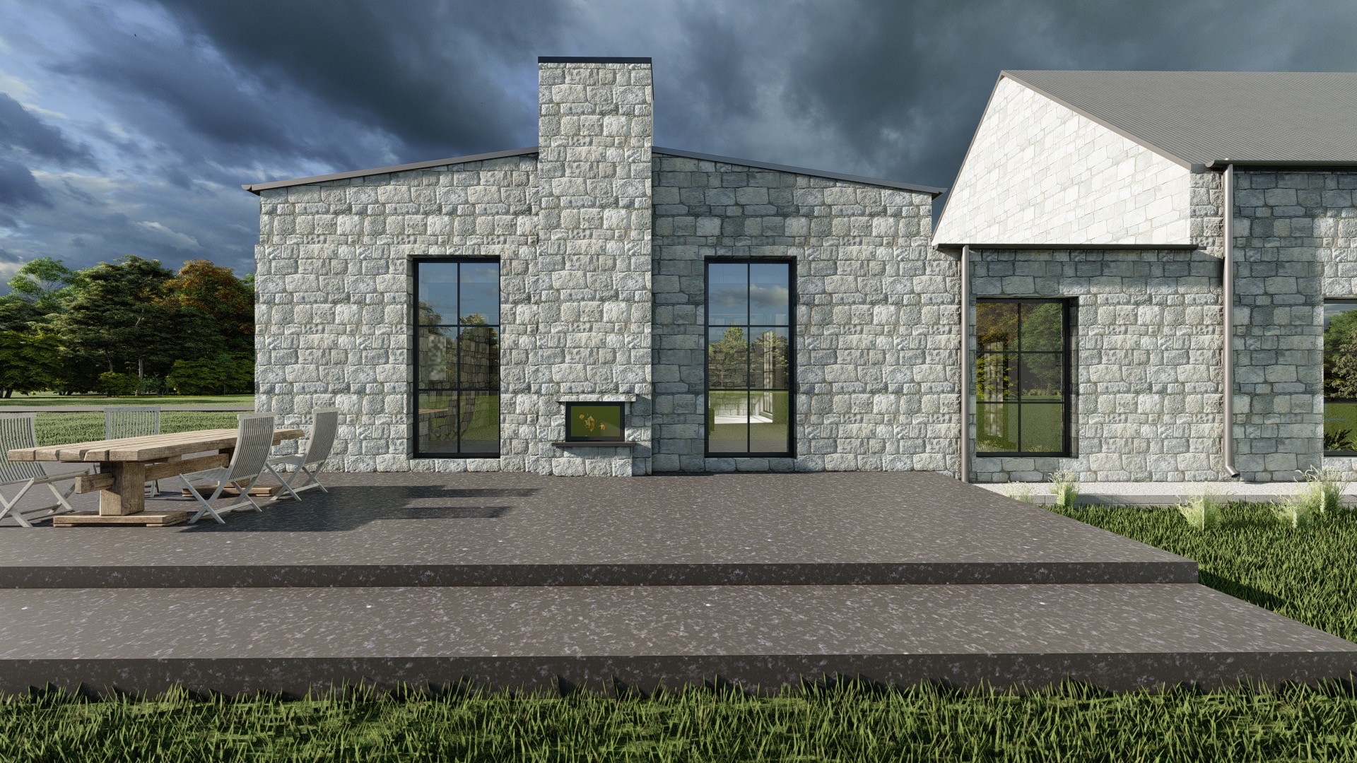Elewacja domu z kamienia z dużymi oknami w czarnych ramach, widok na taras z drewnianym stołem i krzesłami, pochmurne niebo w tle.