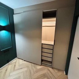 remoglass9 - Nowoczesna szafa wnękowa z przesuwnymi drzwiami, widoczne szuflady i oświetlenie LED wewnątrz, wykończenie wnętrz w Bydgoszczy.