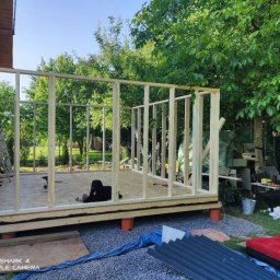 Jonasz Henszel - Konstrukcja drewniana w trakcie budowy, widok z zewnątrz, z narzędziami i materiałami budowlanymi w tle.