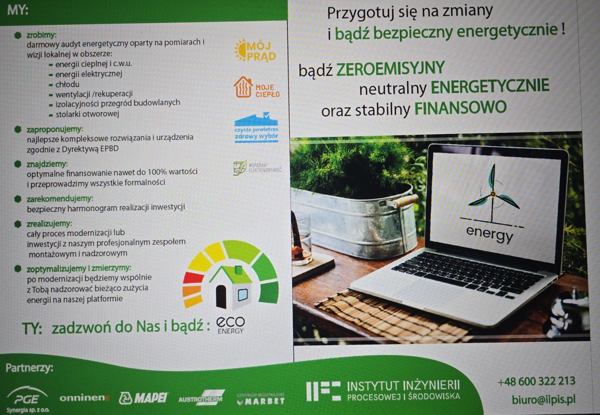 Reklama firmy oferującej audyt energetyczny i rozwiązania związane z odnawialnymi źródłami energii, z laptopem wyświetlającym logo wiatraka i hasło 'energy' w tle, obok metalowego pojemnika...