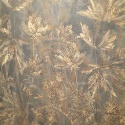 Usługi remontowo budowlane - Położone płytki z motywem roślinnym w odcieniach beżu i szarości, tworzące dekoracyjną ścianę. Widoczne fugi.