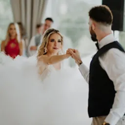 Para młoda podczas pierwszego tańca w chmurze dymu na sali weselnej, widoczny fragment nagłośnienia.