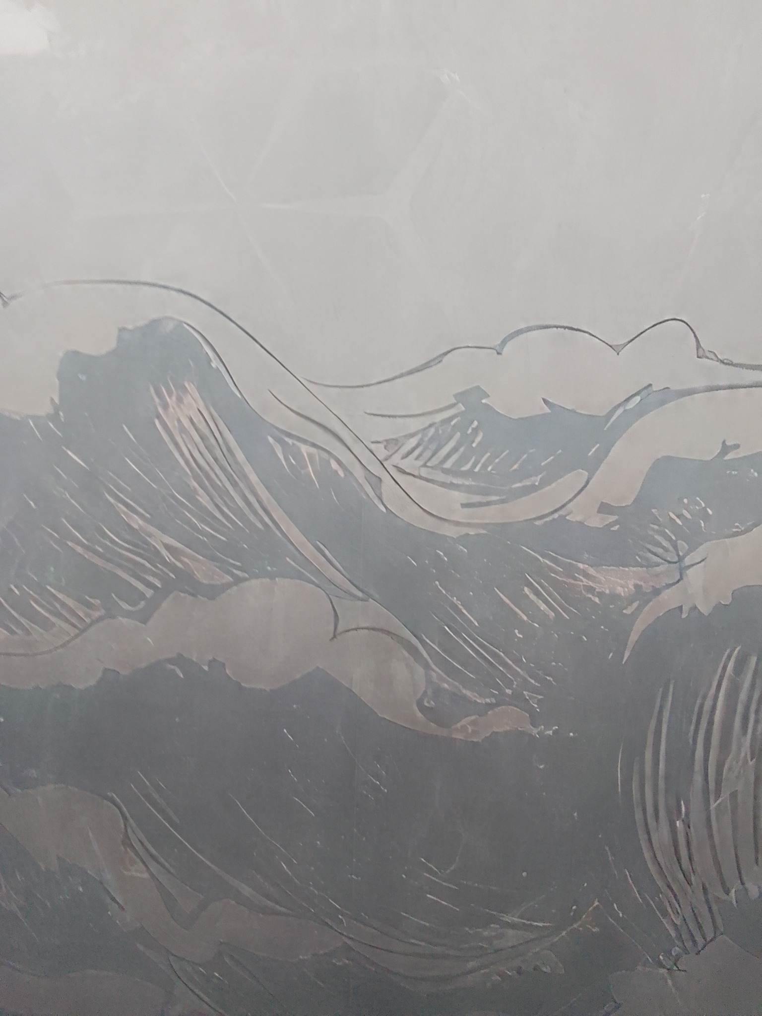 Szklana tafla z piaskowanym motywem fal morskich, widoczne delikatne cieniowanie i faktura.