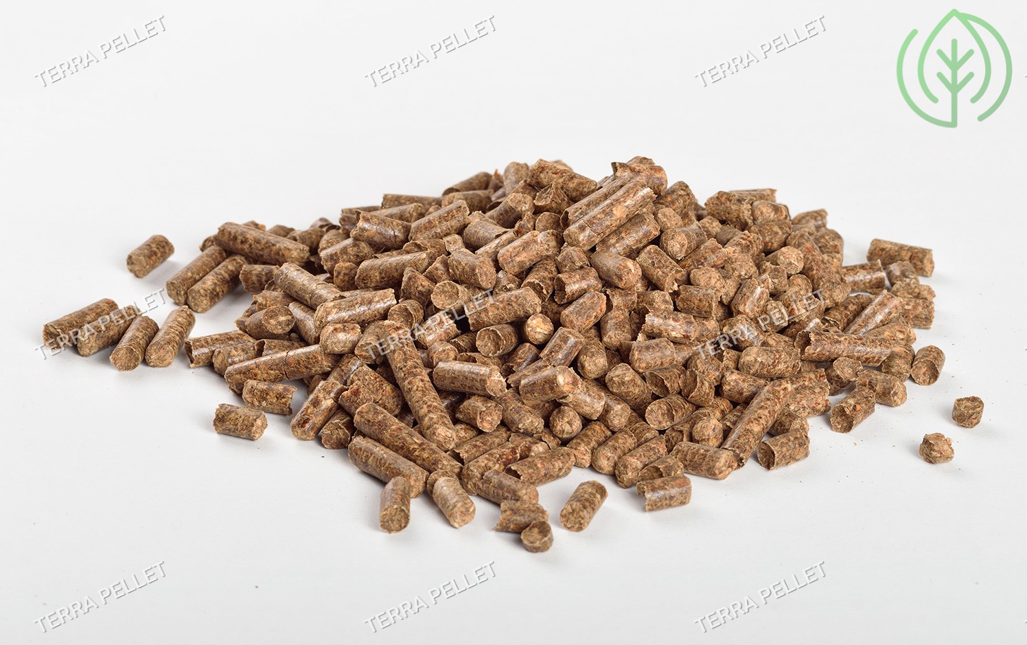 Góra brązowych peletek na białym tle, widoczne ślady po procesie produkcji, w tle logo firmy Terra Pellet.
