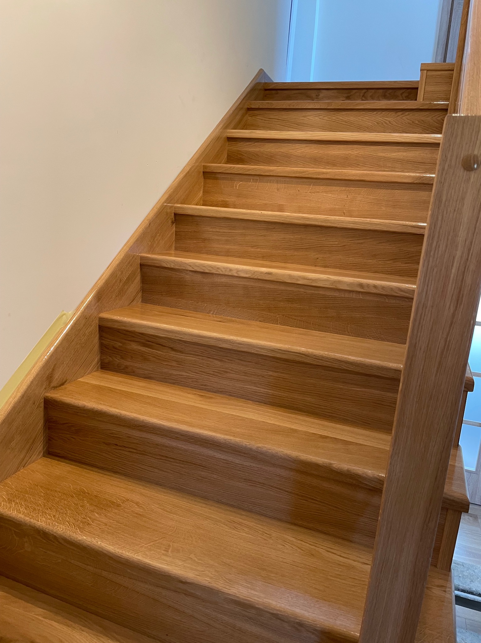 Jasne, drewniane schody z poręczą w Lubieniu. Naturalne wykończenie, widok z dołu, ukazujący detale stopni i solidną konstrukcję.