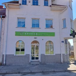 GNHome - Dwupiętrowy budynek apteki z szyldem 'Apteka na Podzamczu' w słoneczny dzień, widok z ulicy.