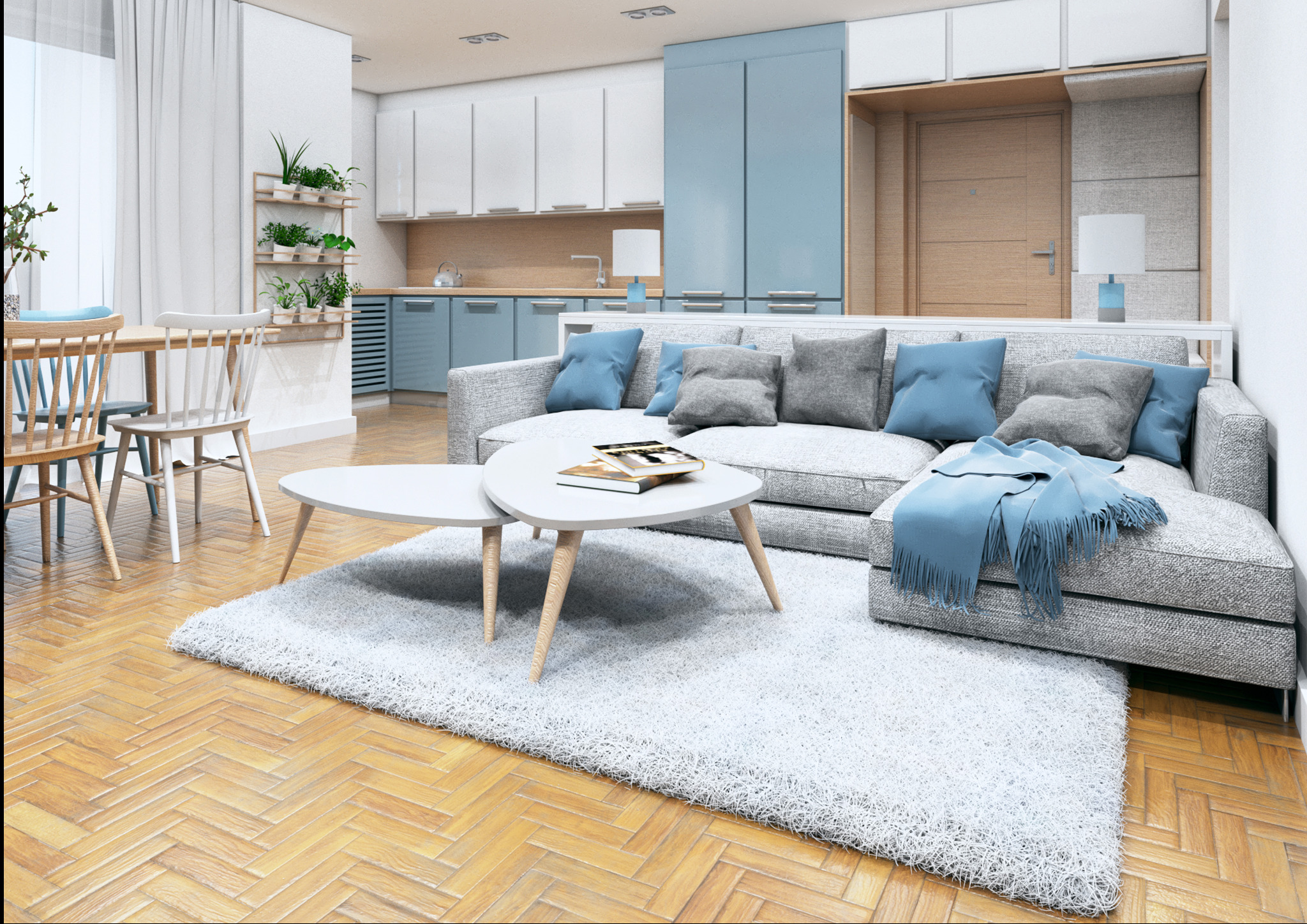 Jasne, przestronne wnętrze mieszkania z parkietem w jodełkę, białym dywanem, szarą sofą z błękitnymi poduszkami i stolikiem kawowym. W tle widoczna kuchnia z błękitnymi szafkami i rośliny na ścianie.
