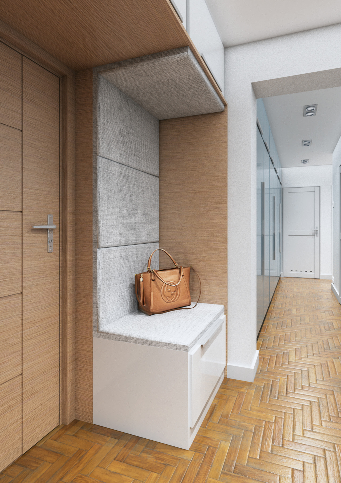 Wnętrze przedpokoju z drewnianą podłogą w jodełkę, zabudowaną szafą z siedziskiem obitym szarą tkaniną, na którym leży brązowa torebka z logo.