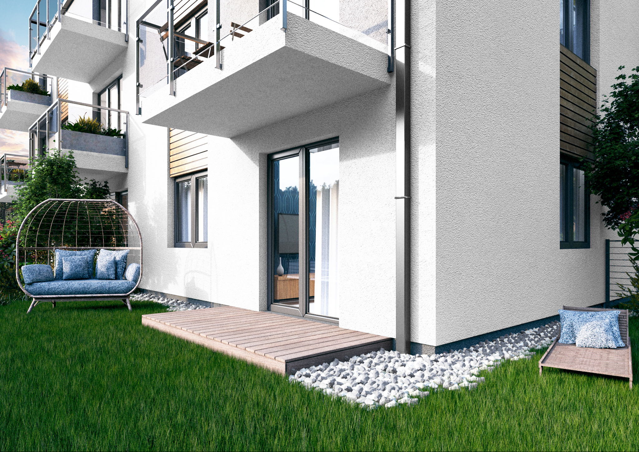 Wizualizacja budynku wielorodzinnego z balkonami, drewnianym tarasem, zewnętrzną strefą relaksu z fotelem wiszącym i leżakiem na trawniku, otoczona białymi kamieniami.