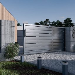 PERFECT - Nowoczesna, przesuwna brama wjazdowa z szarego metalu, z numerem domu '84' na betonowym słupku, otoczona zielenią i żwirowym podjazdem.