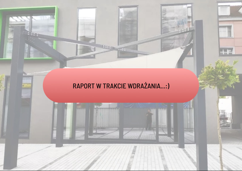 Zadaszenie tarasowe z białym żaglem przeciwsłonecznym, metalowa konstrukcja na tle budynku z szarymi elewacjami i zielonymi ramami okiennymi, widoczny fragment chodnika z jasnej kostki brukowej.