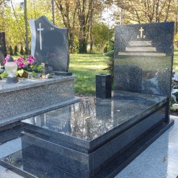 FLINTSTONE GRANIT I MARMUR SPÓŁKA Z OGRANICZONĄ ODPOWIEDZIALNOŚCIĄ - Podwójny, ciemny granitowy pomnik z inskrypcją i krzyżem na tle drzew w jesiennej scenerii.