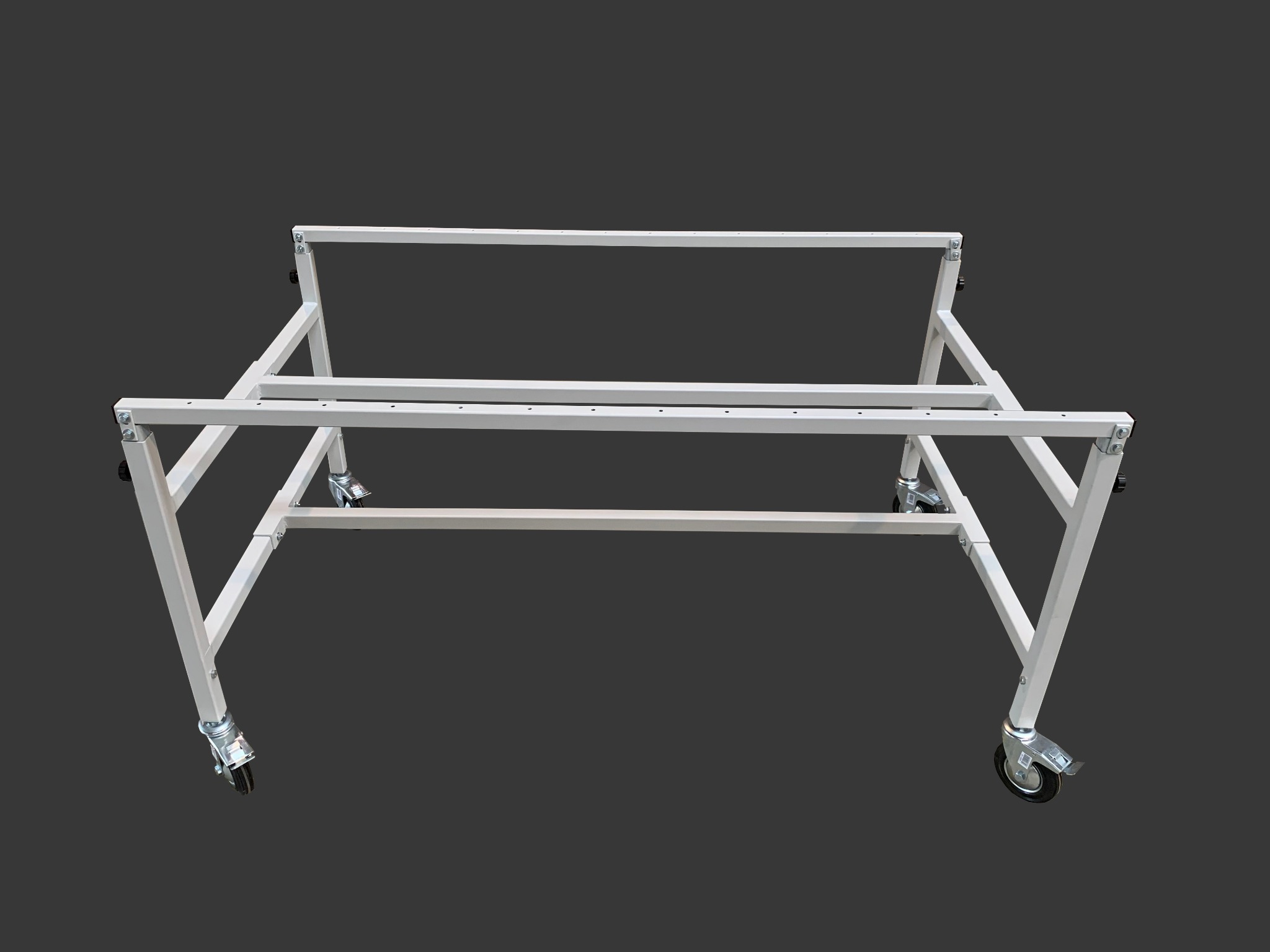 Biała, metalowa konstrukcja na kółkach, spawana z profili kwadratowych, widoczne śruby mocujące, na szarym tle.