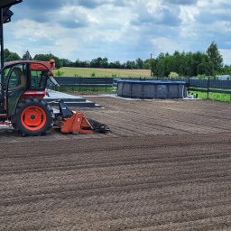 ZOSIATKA SPÓŁKA Z OGRANICZONĄ ODPOWIEDZIALNOŚCIĄ - Czerwony traktor z glebogryzarką przygotowuje ziemię pod trawnik, widoczny basen ogrodowy i fragment domu.