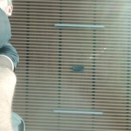 Usługi Elektryczne Czapelski Maciej - Panelowa ściana z poziomymi listwami i oświetleniem LED, widziana z perspektywy osoby stojącej blisko. Fragment ciała osoby widoczny z lewej strony.