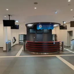 Nowoczesna kasa biletowa z kołowrotami wejściowymi w Jaworze. Widoczne ekrany LCD i oświetlenie LED. Minimalistyczny design.