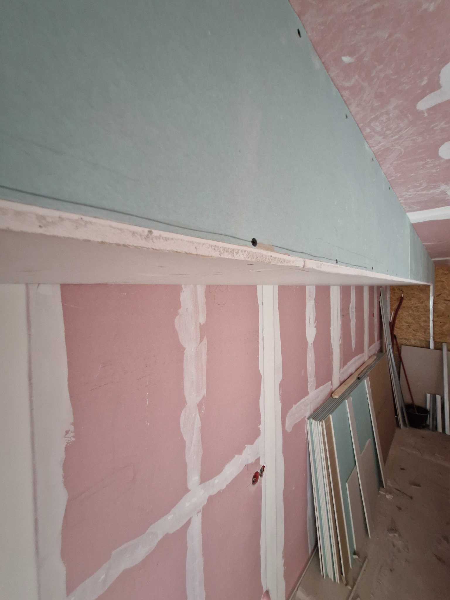 Montaż płyty karton gips na suficie, widoczne profile i wstępnie zagruntowana ściana z instalacją elektryczną