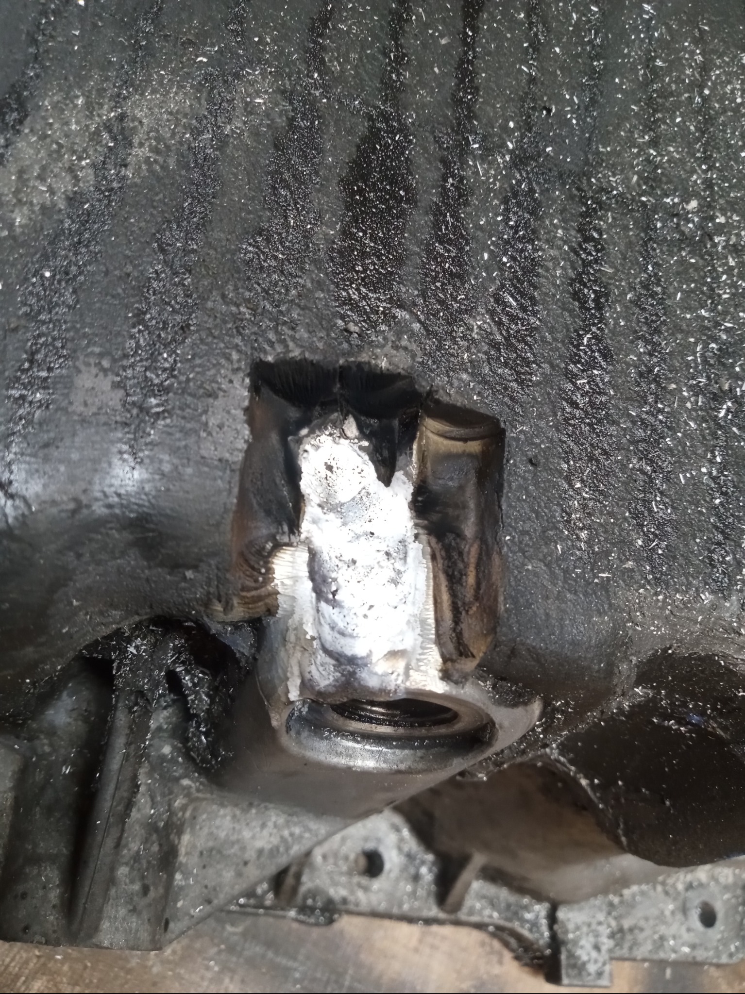 Spawanie naprawcze elementu metalowego w Jurczycach. Detal po obróbce, widoczne ślady spawania i opiłki. Naprawa uszkodzonego gwintu.