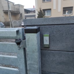 M-tech Michał Śliwczyński - Szara brama wjazdowa z czytnikiem kart zbliżeniowych ZORNO zamontowanym na betonowym słupku.