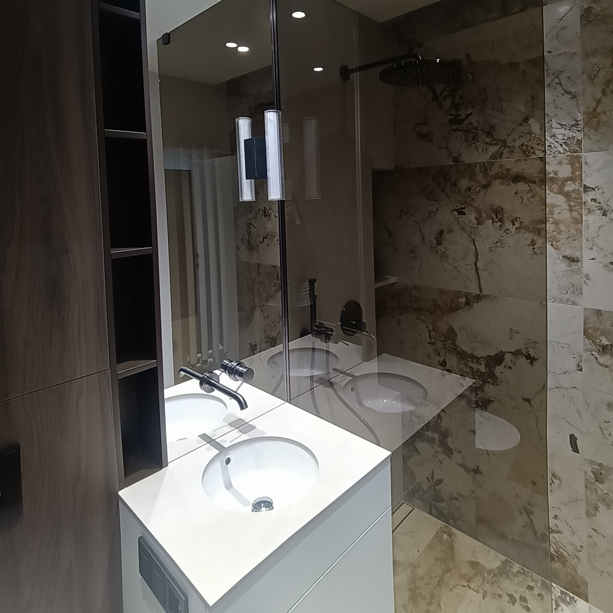 Nowoczesna łazienka z kabiną prysznicową ze szkła hartowanego, umywalką nablatową i marmurowymi płytkami. Minimalistyczny design, eleganckie wykończenie.
