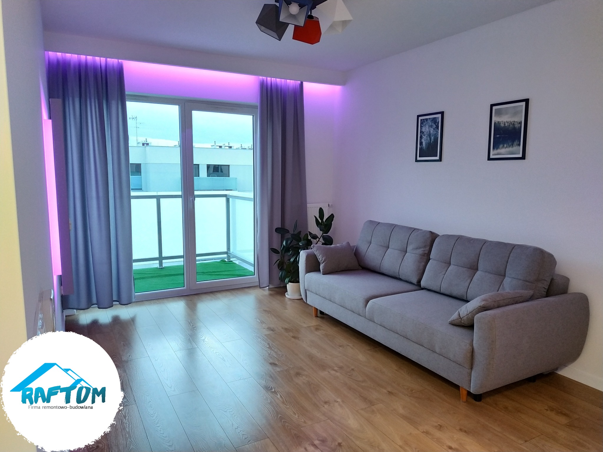 Jasne wnętrze pokoju z szarą sofą, drewnianą podłogą i balkonem z sztuczną trawą, oświetlone fioletowym światłem LED za zasłonami, z logo firmy budowlano-remontowej w rogu