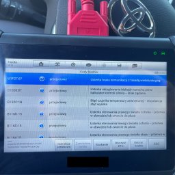CHECK CAR SPRAWDZENIE SAMOCHODU KRYSTIAN KLIMEK - Ekran urządzenia diagnostycznego z listą kodów błędów pojazdu Toyota Proace City, widoczny czerwony kabel diagnostyczny i logo Toyoty w tle.