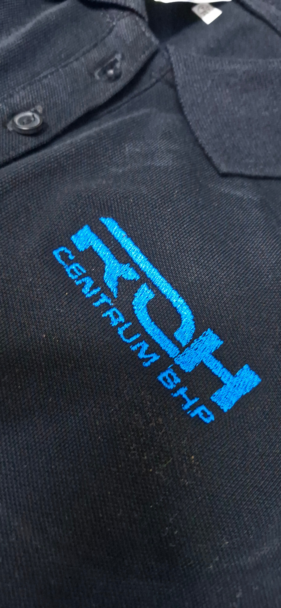 Granatowa koszula polo z wyhaftowanym niebieskim logo 'RDH CENTRUM BHP' na piersi.