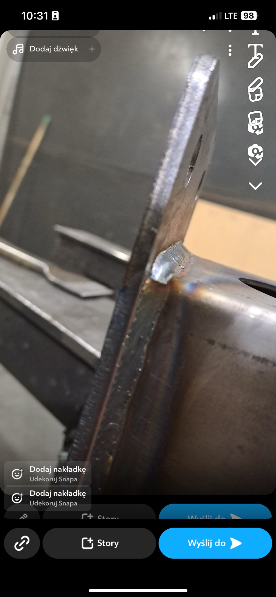 Spoina łącząca metalowy profil kwadratowy z płaskownikiem, widoczne ślady obróbki i niedoskonałości spoiny.