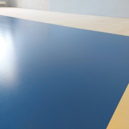 Michał Dobija - Niebieska posadzka żywiczna w nowym pomieszczeniu, widoczny fragment beżowej podłogi i szara ściana w tle.