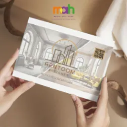Dłonie trzymają wizytówkę firmy Rentoom Designer z grafiką wnętrza salonu w stylu retro, logo z motywem budynków i kodem QR.