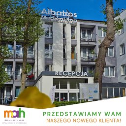MAH - Media Art Home - Sebastian Winnicki - Budynek Albatros Medical Spa z napisem RECEPCJA nad wejściem, widoczny zza drzew, z żółtym elementem graficznym w dolnej części kadru i tekstem 'PRZEDSTAWIAMY WAM NASZEGO NOWEGO KLIENTA!'