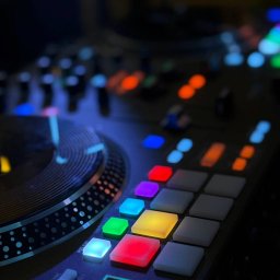 O.B.N.D EVENT - Podświetlony kontroler DJ z kolorowymi przyciskami w odcieniach niebieskiego, zielonego, czerwonego i fioletowego. Widoczny gramofon i przycisk start/stop.