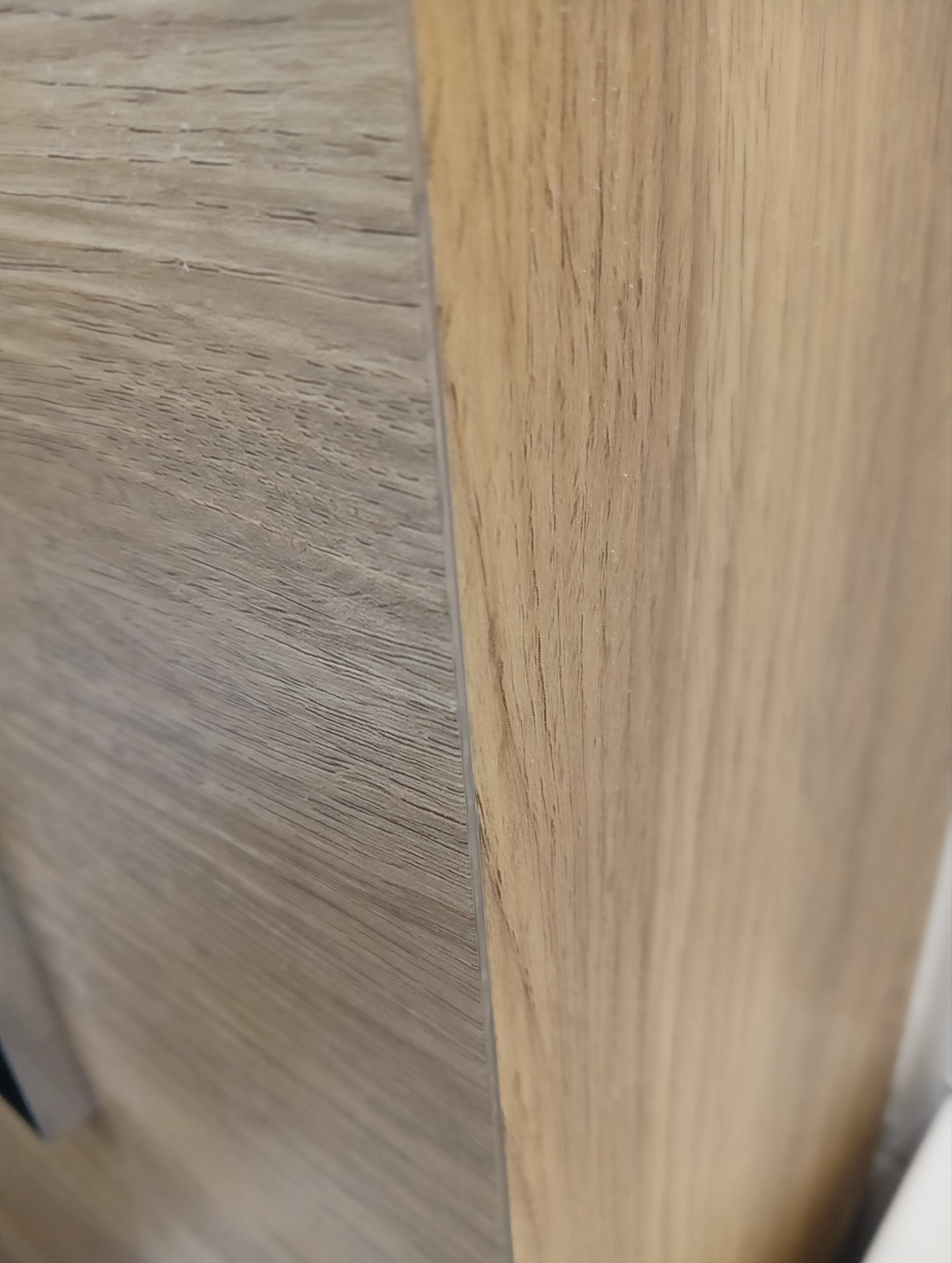 Zbliżenie na połączenie dwóch paneli podłogowych o różnych odcieniach drewna, wykonanych w Wodzisławiu Śląskim, ukazujące precyzję montażu.