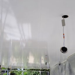 Remont click - Błyszczący, świeżo pomalowany sufit w trakcie instalacji oświetlenia punktowego, ściany częściowo zabezpieczone folią ochronną.